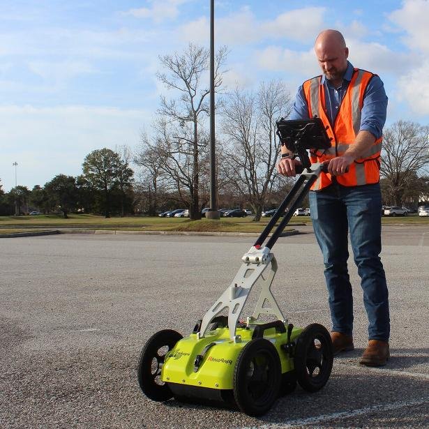Technician using GPR cart on asphalt